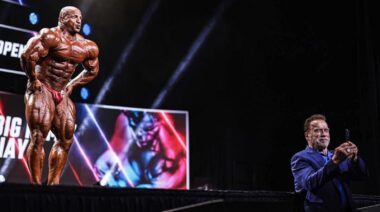 Mamdouh "Big Ramy" Elssbiay poses on stage as Arnold Schwarzenegger takes a selfie.