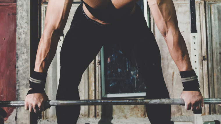 Muscular athletes holding barbell