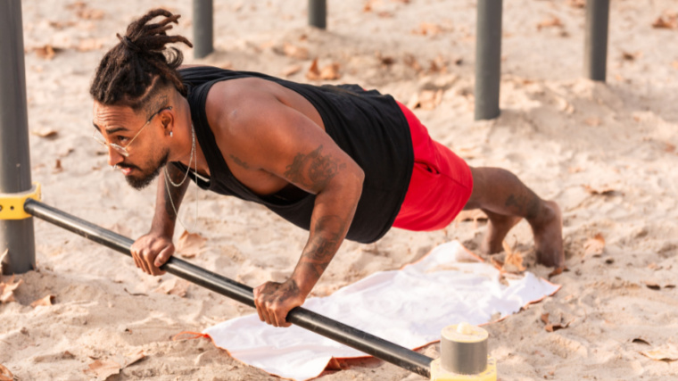 person on beach performing push-ups