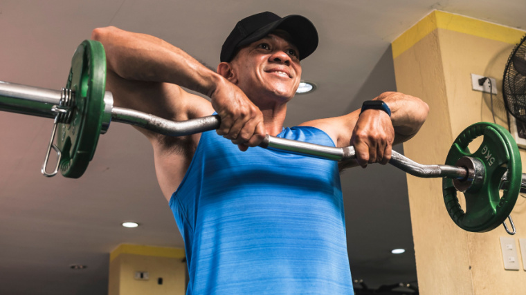 Person in gym doing upright row exercise.