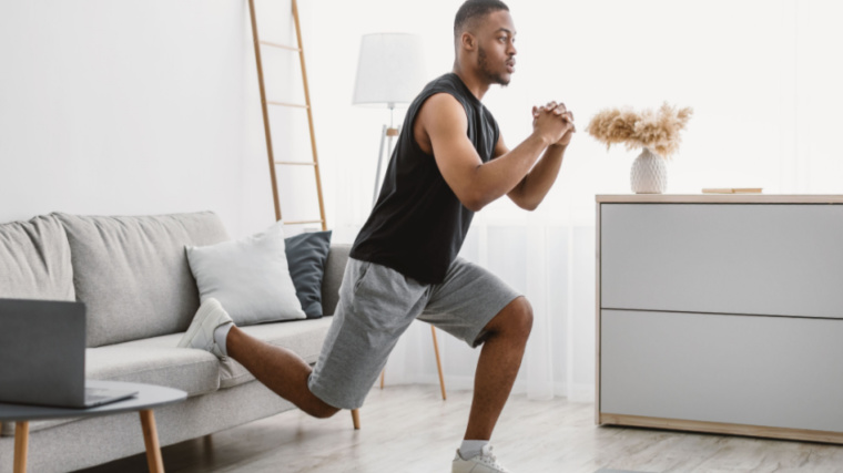 person in home gym performing single-leg squat