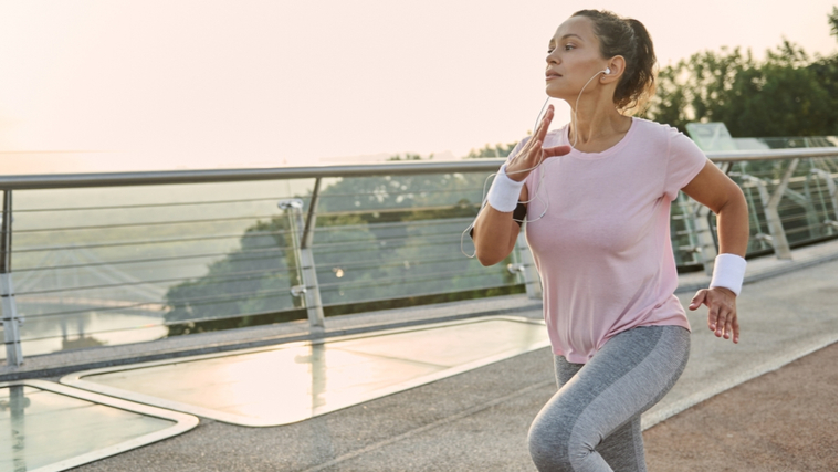 Person running outdoors on boardwalk on bridge