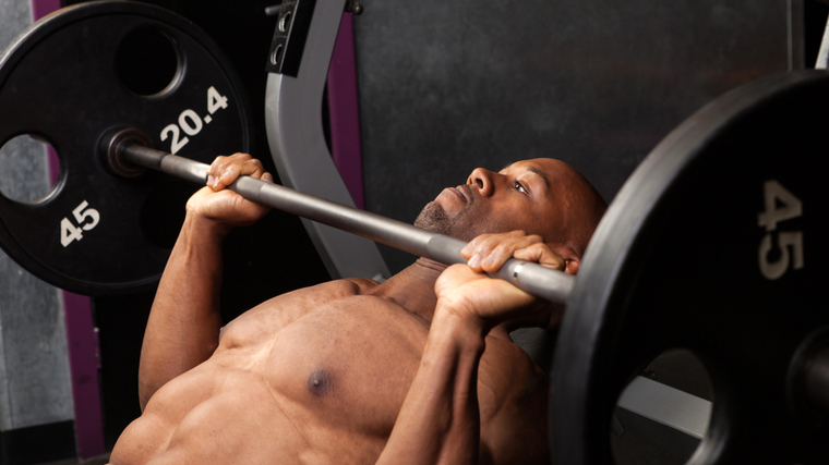 person in gym performing incline bench press