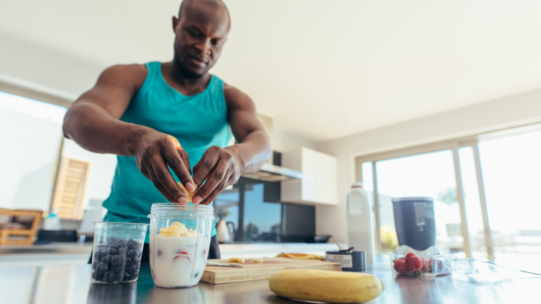 Man in kitchen preparing fruit smoothie shake